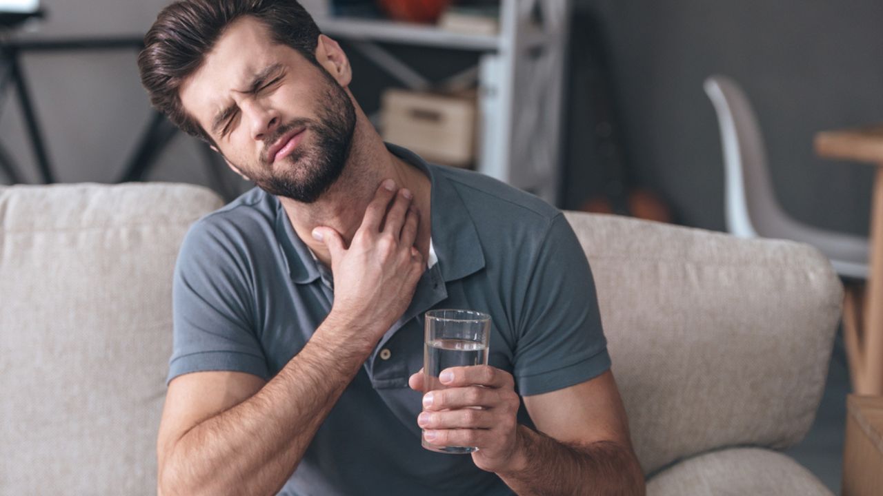 homem tomando remédio para dor de garganta